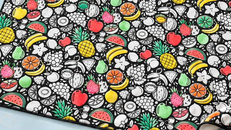 Manta para pintar en parte pintada con rotuladores para tela, sobre una mesa de taller